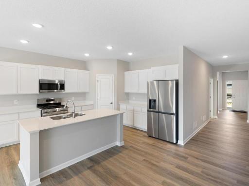 Kitchen. Photo taken of another home with similar plan and finishes. Photos and renderings may not depict actual plan, materials, & finishes may vary. All measurements are approximate.