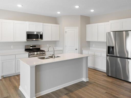 Kitchen. Photo taken of another home with similar plan and finishes. Photos and renderings may not depict actual plan, materials, & finishes may vary. All measurements are approximate.