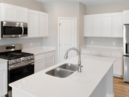 Kitchen. Photo taken of another home with similar plan and finishes. Photos and renderings may not depict actual plan, materials, & finishes may vary. All measurements are approximate.