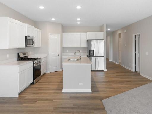 Kitchen. Photo taken of another home with similar plan and finishes. Photos and renderings may not depict actual plan, materials, & finishes may vary. All measurements are approximate.