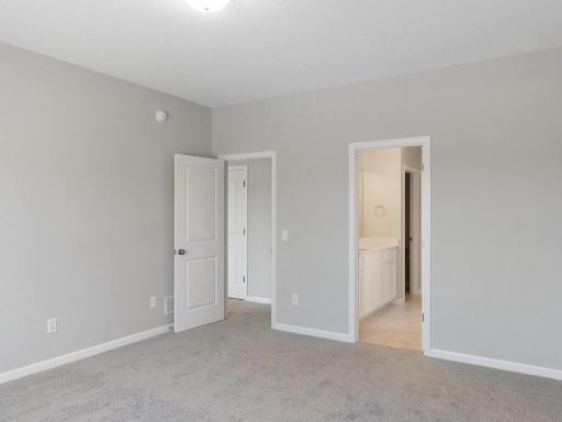 Primary Suite. Photo taken of another home with similar plan and finishes. Photos and renderings may not depict actual plan, materials, & finishes may vary. All measurements are approximate.