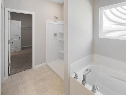 Primary Bathroom. Photo taken of another home with similar plan and finishes. Photos and renderings may not depict actual plan, materials, & finishes may vary. All measurements are approximate.