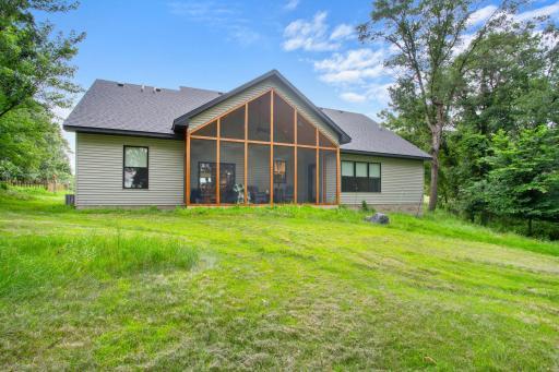 LAKE SIDE OF THE HOME WITH INVITING SCREEN PORCH