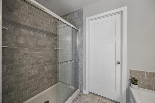 Ensuite includes a large walk-in closet, soaking tub, and tiled walk-in shower.