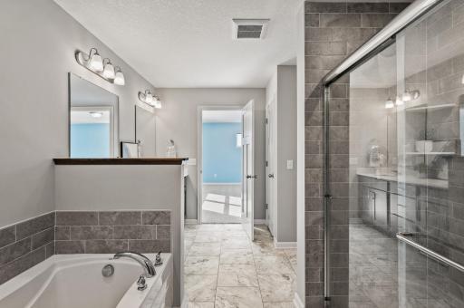 5 piece bathroom ensuite to primary with tiled floor to ceiling walk-in shower
