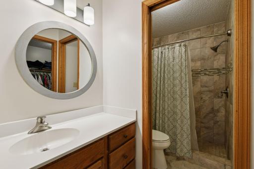 Primary suite bath and shower area with stool..
