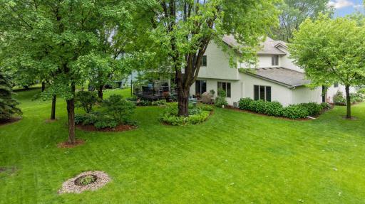 Backyard aerial view with lush landscaping, green space and more.