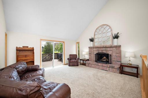 The upper level living room has so much light and an amazingly open feel. The vaulted ceilings, sliding door to the deck and wood fireplace make this a perfect place for family living!
