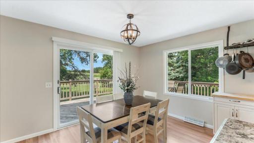 Enjoy meals with a view in this charming dining space, featuring large windows and a sliding glass door that flood the room with natural light.