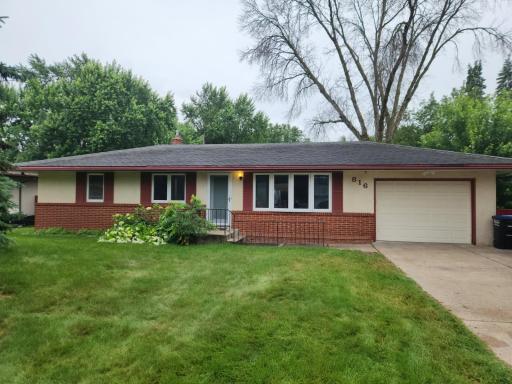 Nice curb appeal at this home with red shutters and brick and a matching patio, wide concrete driveway and large 4 inch downspouts