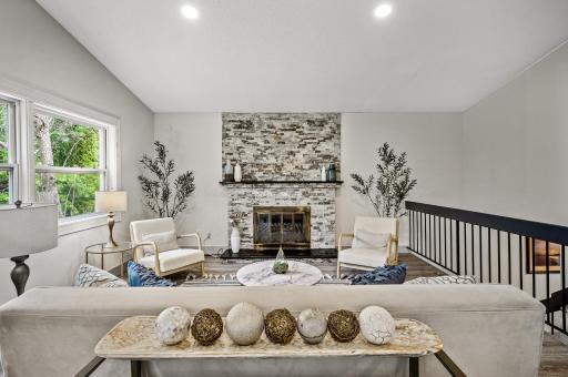 Stone surround fireplace is a great focal point in the vaulted living space