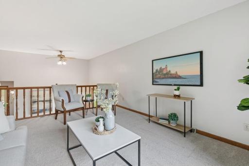 Bright and versatile upper-level living space featuring neutral tones, updated carpet, and a cozy overlook to the main levelâperfect for a reading nook or lounge area.