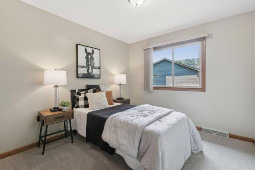 Cozy guest bedroom featuring brand new carpet, neutral tones, and plenty of natural lightâperfect for visitors, a home office, or flex space.