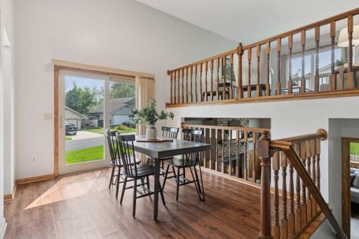 Open-concept dining area with beautiful sightlines to both the upper and lower levels. Rich wood-style LVP flooring and natural light create a warm and connected feel throughout the home.