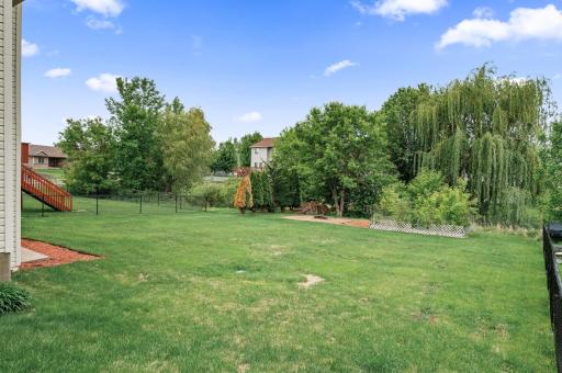 This great size backyard features a paver patio/firepit area with a garden next to it.