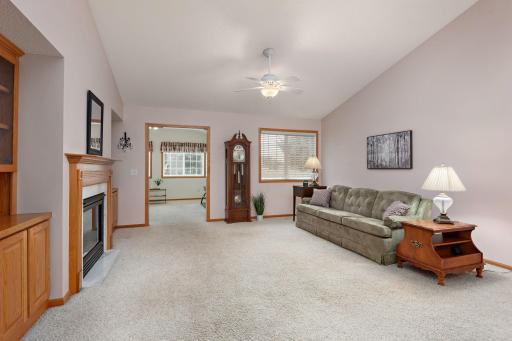 Living room with vaulted ceiling, open to sunroom and dining room (to right of photo).