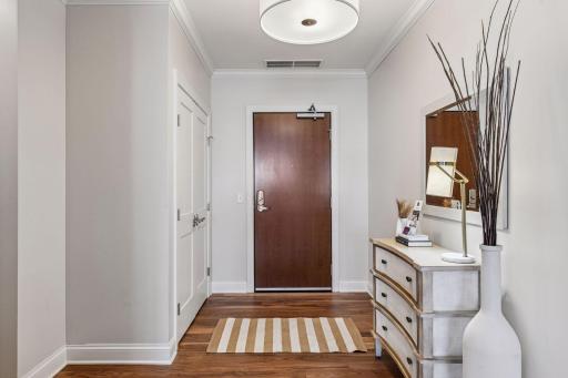 Spacious entry foyer with walnut floors, ample closet and updated lighting.