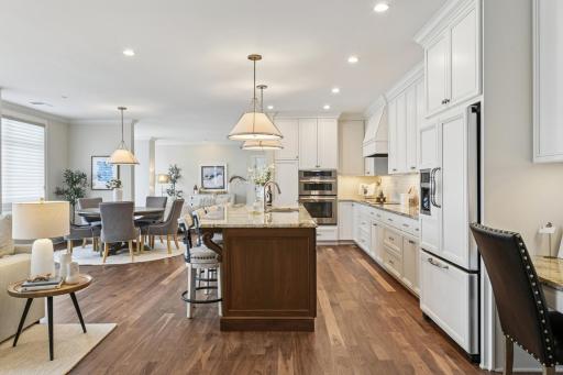 The large kitchen has walnut center island, granite countertops, white subway tile backsplash and Jenn-Aire appliances.