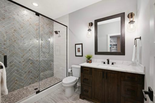 Another beautifully tiled walk-in shower with glass door.