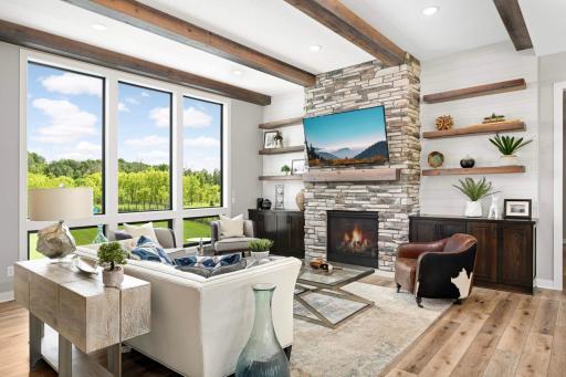 Great room overlooks the pool and private back yard and features a gas fireplace with stone surround and mantle, built-ins for storage and wood shelves.