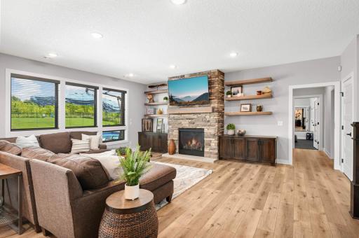 This family room features a gas fireplace with stone surround and wood mantle, built-in cabinets for storage, wood display shelves, and walks out to a huge concrete patio and in-ground pool. Down the hall are the theater and exercise rooms.