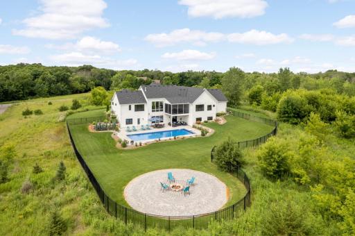 This backyard is a true outdoor oasis, featuring a saltwater pool, patio for lounging & entertaining, covered patio for shaded relaxation, fenced yard for your pets, and a paver patio with firepit for a night under the stars