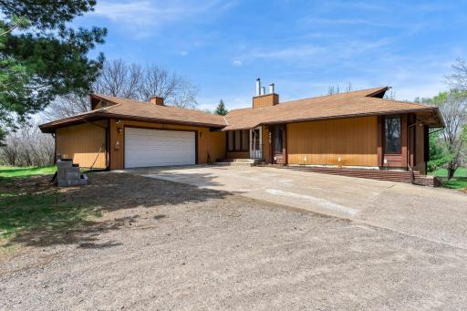 This five-bedroom, three-bathroom home is nestled on nearly four acres of serene, private land near Coon Creek, Majestic Oaks Golf Club, and Hickory Meadows Park.