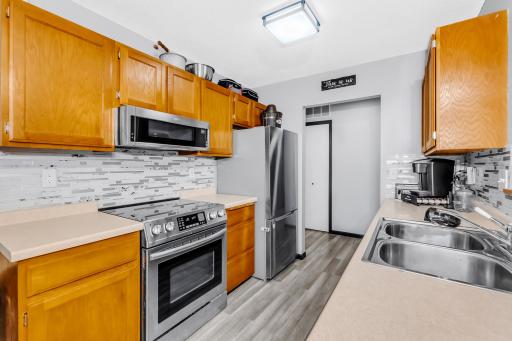 galley kitchen features newer stainless steel appliances