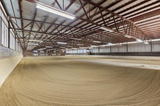 100' x 200' heated Indoor Arena - Steel Construction - 6' observation aisle on north side of indoor - Footing: fine to medium sand with sub-angular particles over an aglime base. New sideboards Nov 2025