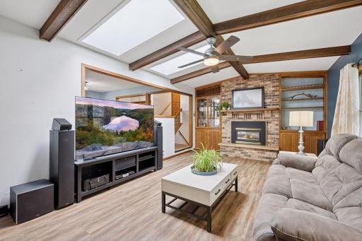 The living room is complete with a wood burning fireplace and brick surround with build in shelving.