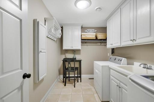 Full laundry room with cabinetry and built in ironing board with room for a work table and crafting area