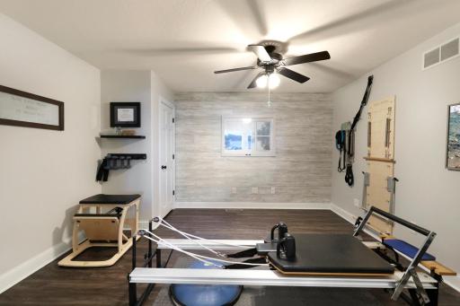 Exercise studio, office, or flex room has vinyl plank flooring, French doors, and oversized storage closet - equipment to be removed