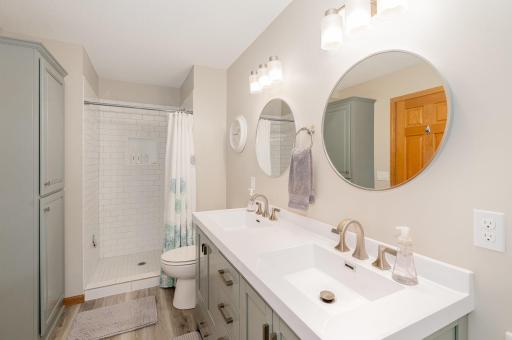 The private, primary, full bathroom was updated in 2022: flooring, paint, door hardware, toilet, comfort height vanity w/double sinks, faucets, towel ring & hooks, mirrors, light fixtures, & subway tile shower (with product nook & shaving pedal).