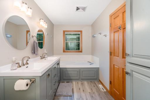 The primary bathroom also features a soaking tub; and updated: quiet exhaust fan (2022) and window (2020) overlooking the lush backyard. There is also a retractable clothes line above the tub, for drying your more delicate clothing.