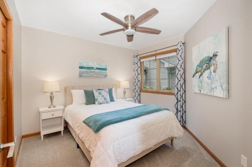 This cozy, bedroom is the perfect retreat for guests. It features updated: carpet, paint, door hardware, window & ceiling fan. Located next to the 1/2 bath w/updated: flooring, paint, vanity, sink top, faucet, mirror, light fixture, toilet & storage.
