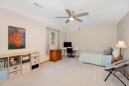 This spacious 18.5x12.2 lower level bedroom features updated: carpet, paint, east-facing daylight window, and ceiling fan.