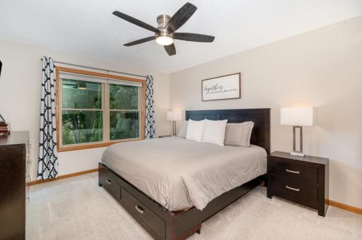 This primary bedroom suite features a 8.11x5.10 walk-in closet and updated: carpet, paint, door hardware, windows & ceiling fan. Curtains are not included. This room offers gorgeous views of the lush backyard & wildlife area. TV mount is included.