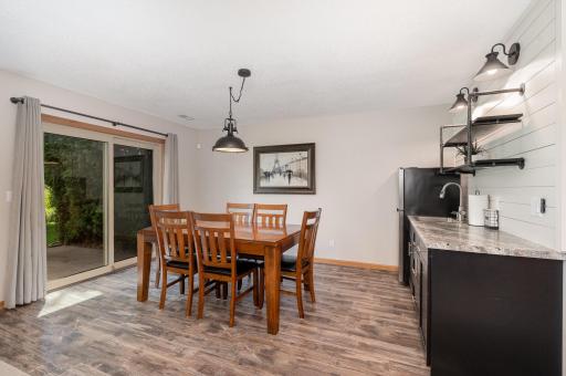This lower level kitchenette was installed in 2023. It features updated: flooring, paint, light fixtures, stainless steel refrigerator, custom cabinets (w/soft close doors & drawers), sink & faucet, shiplap wall, and floating shelves.