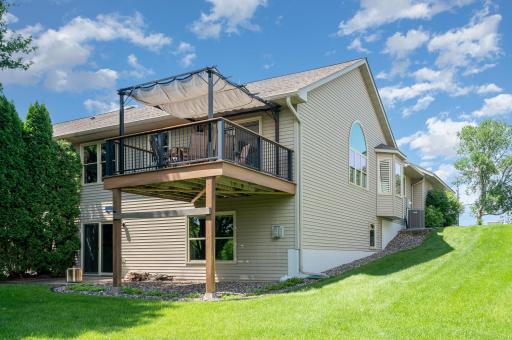 A view of the backyard patio & deck. The Solo Stove & wood (on the patio) are included; as well as the attached maintenance-free Pergola (w/sunshade & fairy lights) on the deck. An additional sun shade (for west wide of the deck) is also included.