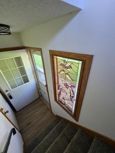 Entrance Into The Home To The Right & The Garage To The Left... Beautiful Stained Glass Window... All New Carpet Throughout...
