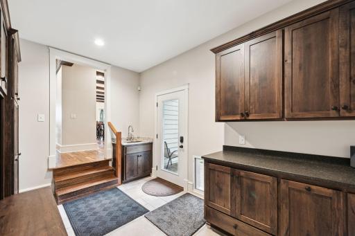 This spacious mudroom between the kitchen and attached garage features custom cabinetry, built-in lockers, and a convenient sink helping you stay organized in your day-to-day life.