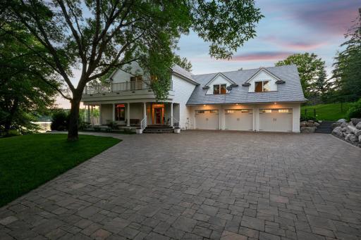 This impressive lake home showcases timeless architectural detail and thoughtful design. The expansive paver motor court leads to a 1,000+ sq ft heated garage with an epoxy floor offering, ample space for you and your guests to enjoy lakeside living.
