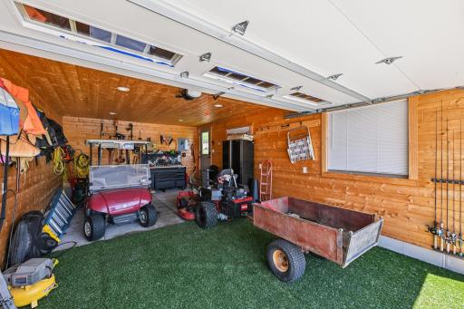 Interior view of the boathouse featuring a 7.5x14 overhead door, tongue-and-groove walls, and ample space for lake gear, tools, and toysâideal for effortless lakeside living.