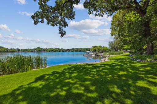 Mature trees provide dappled shade over a lush, level lawn that stretches to the waterâs edge. With panoramic views, tranquil surroundings, and easy water access, this outdoor space is ideal for relaxing, entertaining, or heading out on the lake.