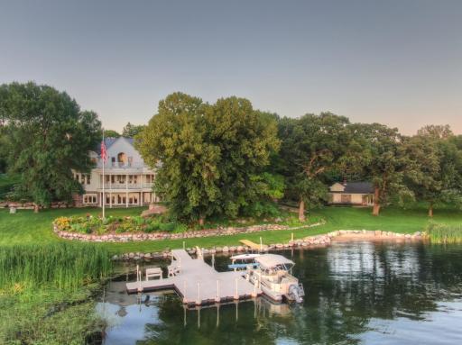 Iconic West Lake Sylvia estate featuring nearly 400 feet of shoreline, private docks, tiered gardens, and a charming guest cottage all with golf cart access and no steps to the water. A rare blend of luxury and lakeside ease.