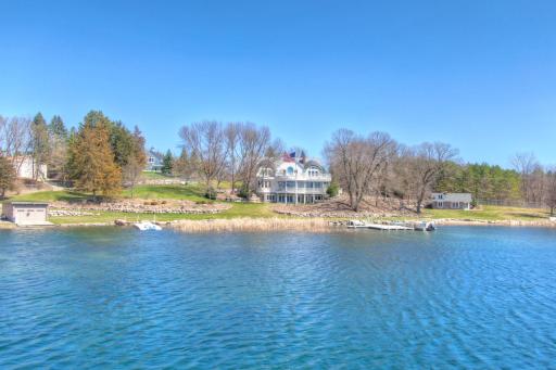 A stunning lakeside perspective of this private West Lake Sylvia estate, showcasing its expansive shoreline, beautifully manicured grounds, guest cottage, and dual docks. Surrounded by mature trees and natural beauty has unmatched tranquility.