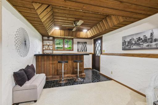 Wet bar area with tray ceiling and walk out to backyard