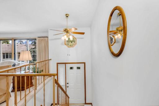 As you step inside, you're greeted by a spacious entryway boasting a stunning vaulted ceiling. The ceiling's height allows for a beautiful window that bathes the space in natural light, creating a warm and inviting atmosphere.