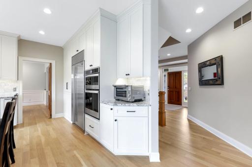 From the informal dining room, enjoy an elegant sightline through the formal dining area and toward the welcoming front entrance. The open layout offers a natural flow, drawing you through thoughtfully designed spaces.