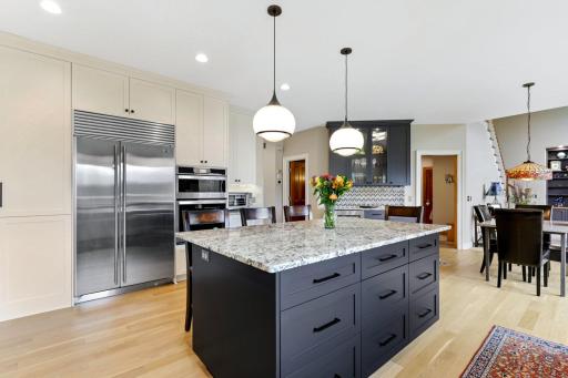 Designed with both culinary passion and elegant entertaining in mind, the gourmet kitchen features a Sub-Zero refrigerator, a wall oven and microwave, and a striking 7-foot granite island that anchors the space with style and function.